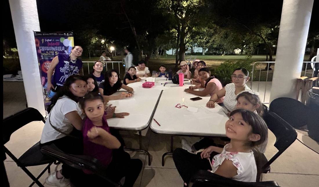 Familias en mesas durante una función nocturna en comunidad