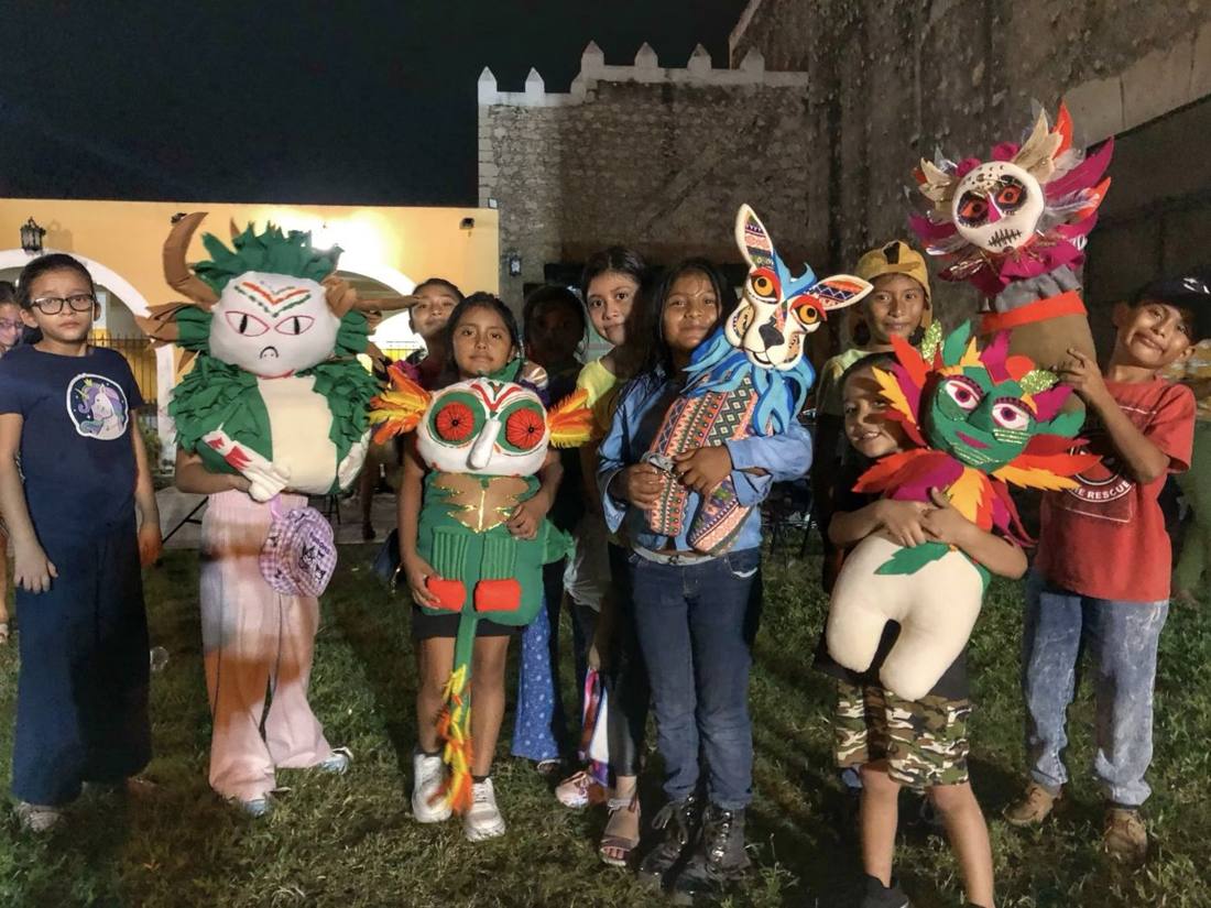 Niñas y niños con máscaras en una función nocturna en comunidad