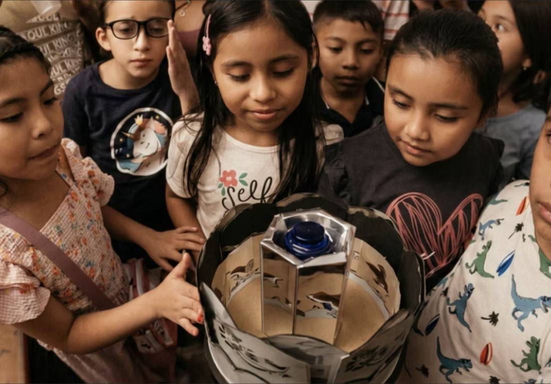 Niñas observando una pieza construida en el taller